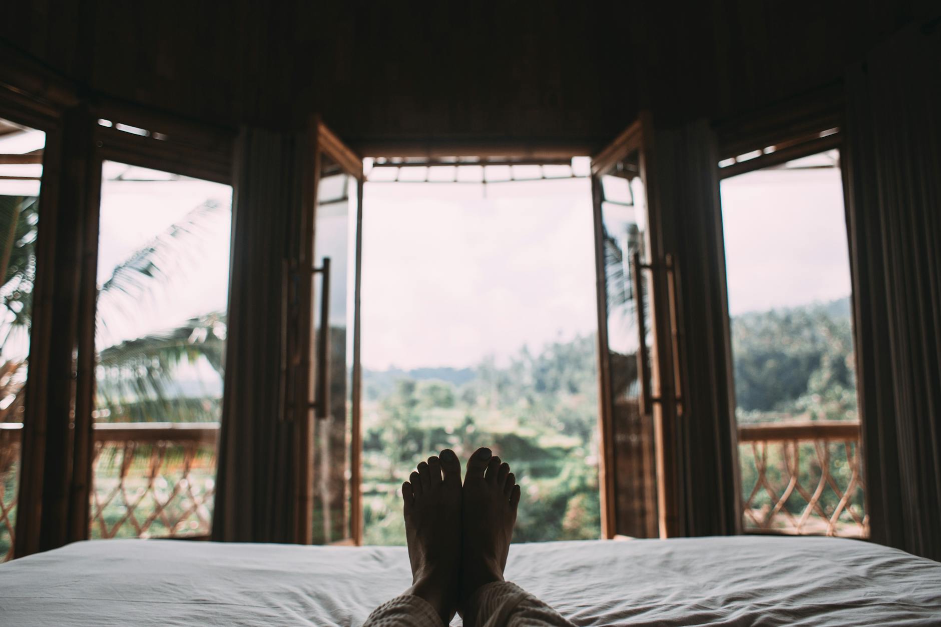 faceless person resting on bed in room